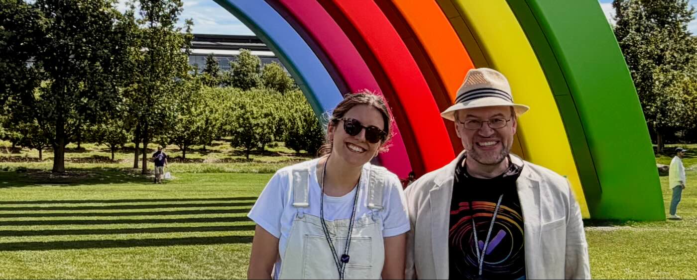Ainsley and Ken in front of the rainbow at Apple Park, during WWDC26)
