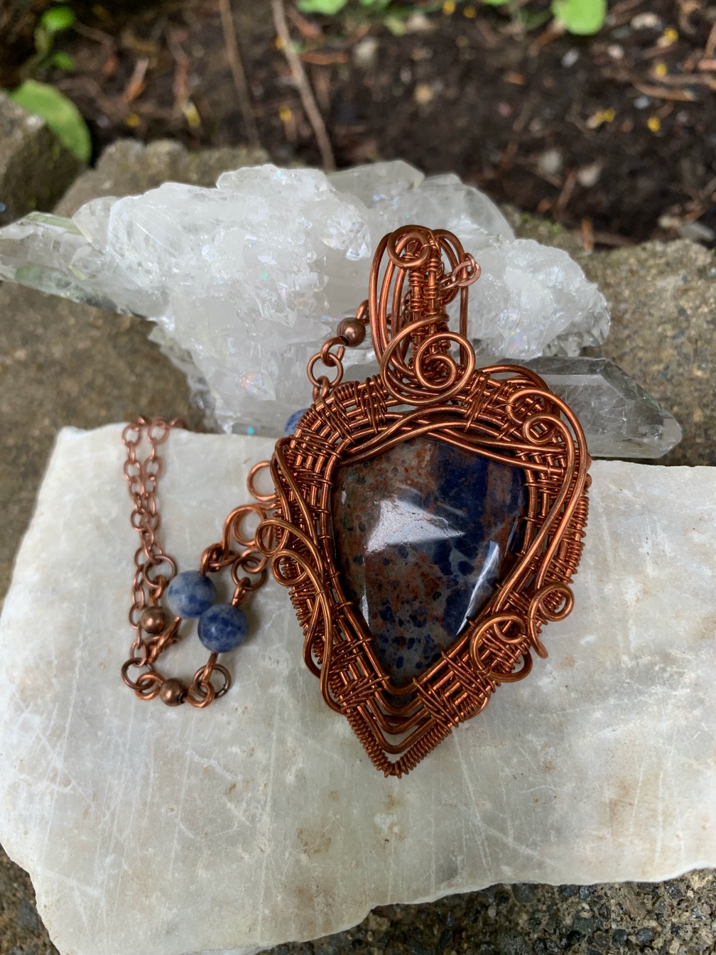 Blue stone ornately wrapped with copper wire.
